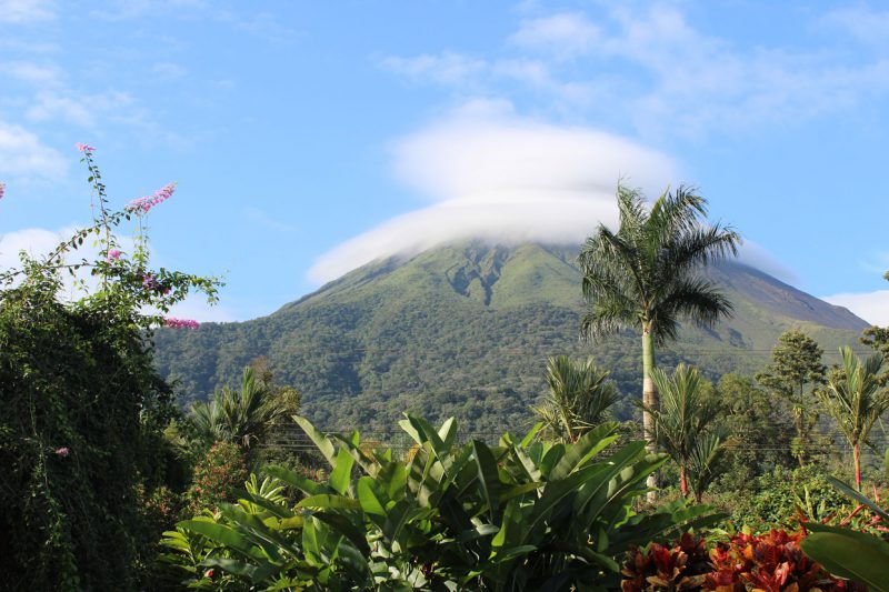 widok u podnóża na zasłonięty chmurą stożek wulkaniczny Arenal położony w Kostaryce