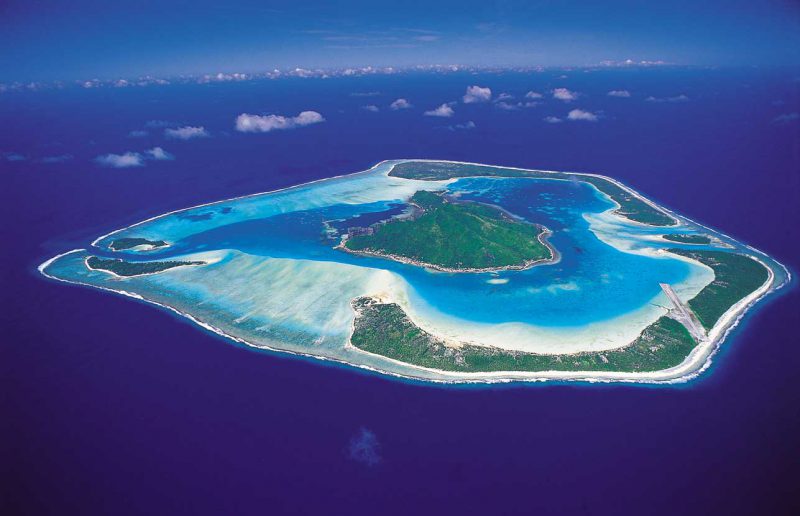 atol zanurzony w jasnoniebieskiej wodzie z plażami o białym piasku, Polinezja