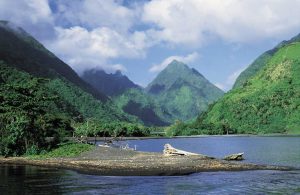 wysokie, pokryte zielenią, otoczone chmurami szczyty gór Tahiti położone nad oceanem