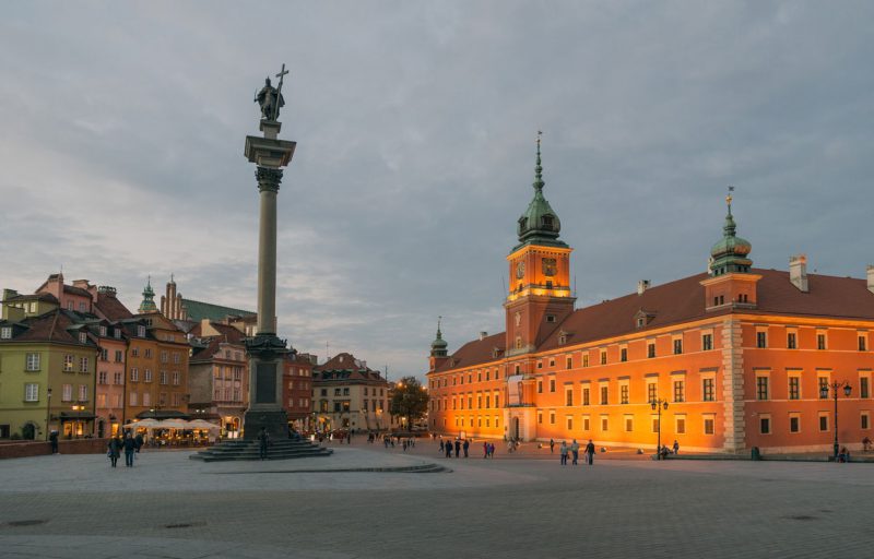 widok na plac zamkowy w Warszawie, oświetlony wieczorem Zamek Królewski