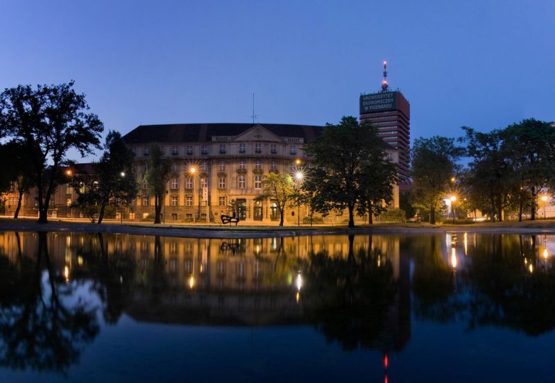 widok na położony nad wodą, oświetlony nocą budynek Uniwersytetu Ekonomicznego w Poznaniu