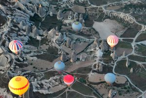 widok z lotu ptaka na lecące nad Kapadocją kolorowe balony turystyczne